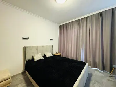 a bedroom with a large bed and a window at AQUA BLUE APARTMENTS 38 Penthouse Sunny Beach in Sunny Beach