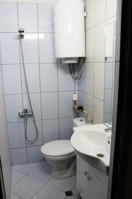 a white bathroom with a toilet and a sink at Иглика Апарт Несебър in Nesebar