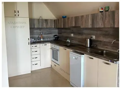 a kitchen with white appliances and wooden walls at Top floor luxury apartment in Sunny Beach in Sunny Beach
