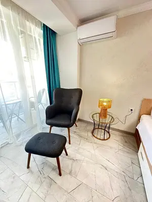 a bedroom with a chair and a table and a lamp at Hotel Solemar in Sunny Beach