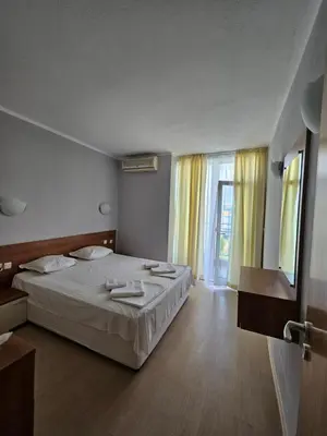 a bedroom with a bed and a large window at Тристаен просторен апартамент с две отделни спални in Sunny Beach