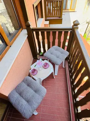 a balcony with a table and chairs on a porch at Guest House Amfora with a sea view in Sozopol