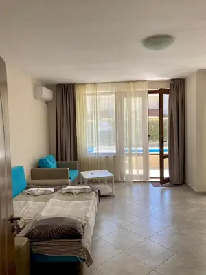 a hotel room with two beds and a living room at Apartments in Villas Apolon in Sozopol
