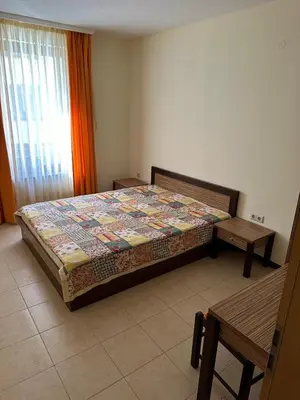 a bedroom with a bed and two tables in it at 2 Room Apartment Royal Sun Sunnybeach in Sunny Beach