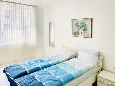 a bedroom with a bed with blue and white sheets at Park suite in Burgas City