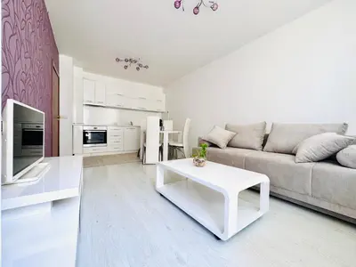 a white living room with a couch and a table at Park suite in Burgas City