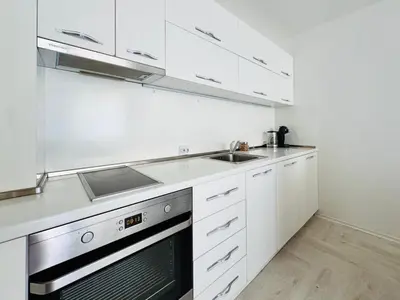 a kitchen with white cabinets and a sink and a stove at Park suite in Burgas City