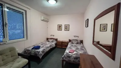 a room with two beds and a couch and a mirror at Relax in Riviera in Sveti Vlas