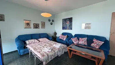 a living room with a blue couch and a table at Relax in Riviera in Sveti Vlas