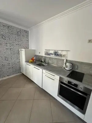 a white kitchen with a sink and a refrigerator at Oasis Beach Club - 