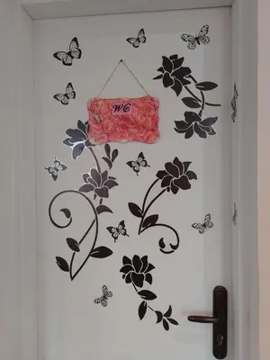 a wall with flowers and butterflies on it at Студио Свежест in Pomorie