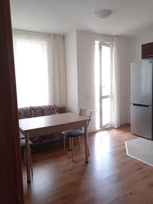 a living room with a table and a couch at Тристаен апартамент в Бяла комплекс Атлантик in Byala