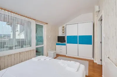 a bedroom with a white bed and a large window at Sirena Seaview Apartment - FREE PARKING in Varna City