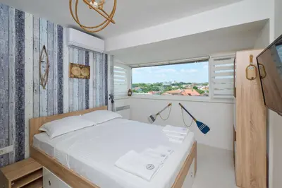 a bedroom with a white bed and a window at Sirena Seaview Apartment - FREE PARKING in Varna City