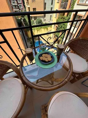a table with a plate of food on a balcony at Свети Влас комплекс Викторио in Burgas City