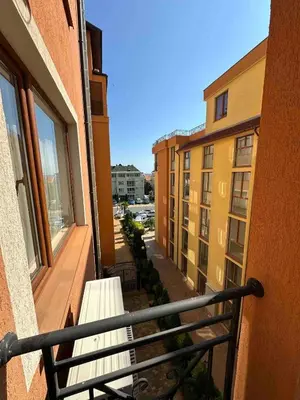 a balcony with a bench and some buildings at Свети Влас комплекс Викторио in Burgas City
