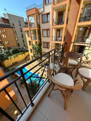 a balcony with two chairs and a table on a building at Свети Влас комплекс Викторио in Burgas City