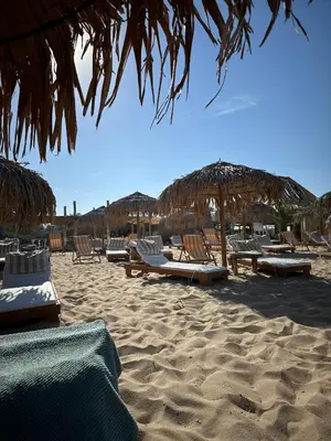 a group of chairs and umbrellas on a beach at 2 Zimmerwohnung in Shkorpilovtsi
