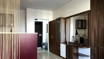 a kitchen with wooden cabinets and a red door at Apartment 7 in Sozopol