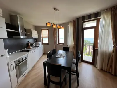 a kitchen with a table and a dining room at Saint Thomas Holiday Village Condo in Sozopol