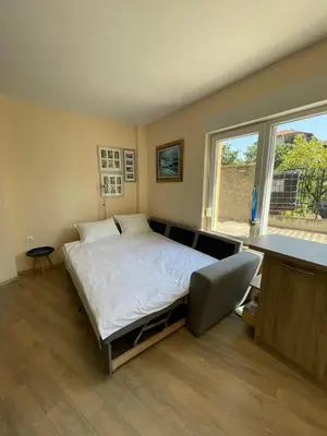 a bedroom with a bed with a desk and a window at Sarafovo Summer 1 - Relaxing Apartment Near Beach in Sarafovo