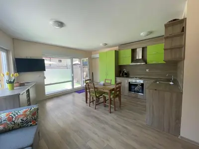 a kitchen with green cabinets and a table and chairs at Sarafovo Summer 1 - Relaxing Apartment Near Beach in Sarafovo