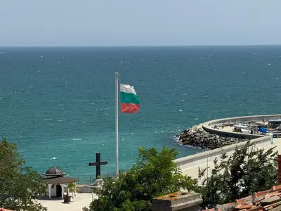 a flag on a pole in front of the ocean at Anastra in Pomorie