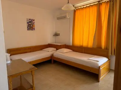 two beds in a room with an orange curtain at Anastra in Pomorie