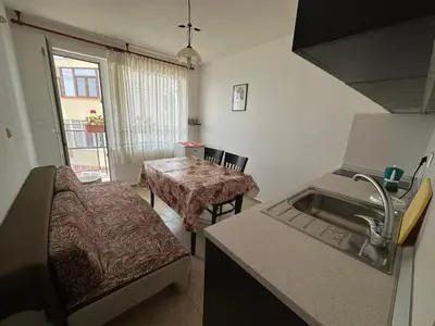 a kitchen with a table and a sink in a room at Anastra in Pomorie