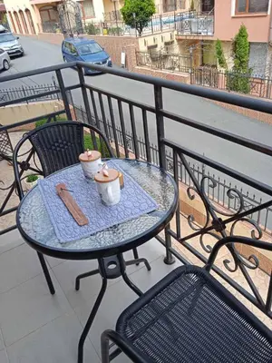 a table and chairs on a balcony with food on it at Cozy studio 150m from the beach in Sveti Vlas
