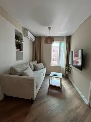 a living room with a couch and a table at Lazur Beach Residence - 10min walk to beach in Burgas City