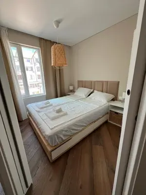 a large bed in a room with a large window at Lazur Beach Residence - 10min walk to beach in Burgas City