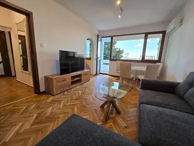 a living room with a couch and a tv and a table at Super Lovely Apartment in Burgas City