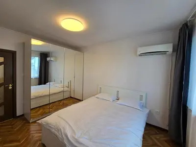 a bedroom with a white bed and a mirror at Super Lovely Apartment in Burgas City
