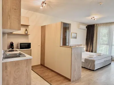 a kitchen with a sink and a bed in a room at Sea View Allure Studio with Balcony in Primorsko