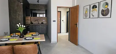 a dining room and kitchen with a table and chairs at Ika Delux in Burgas City