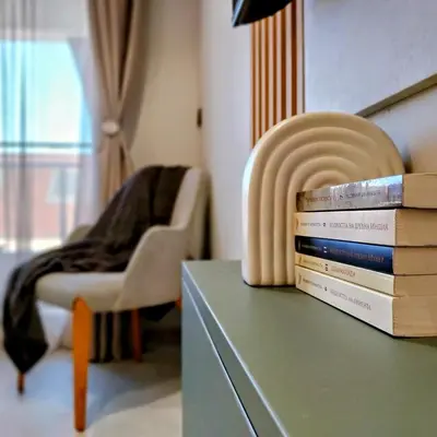a stack of books sitting on a table next to a chair at Ika Delux in Burgas City