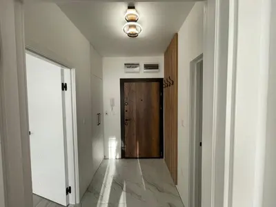 a hallway with a wooden door and a hallway with white walls at Сарафово Family in Burgas City