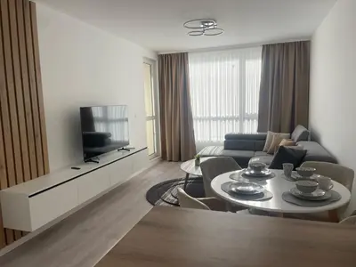 a living room with a couch and a table and a television at Сарафово Family in Burgas City