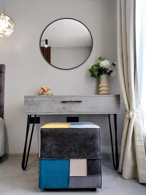a table with a mirror and a stool under it at Ika Apartment Central in Burgas City