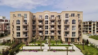 a large apartment building with a garden in front of it at Marea Garden Apartment Ravda in Ravda