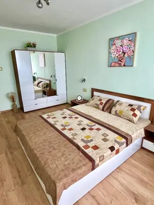 a bedroom with a large bed with a large mirror at PanoramaView Lazur in Burgas City