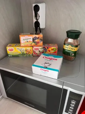 a shelf with boxes of food on top of a microwave at PanoramaView Lazur in Burgas City