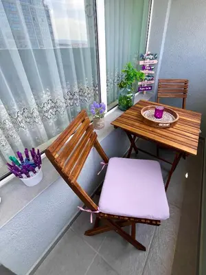 a bench and a table and a chair on a balcony at PanoramaView Lazur in Burgas City