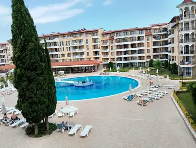 a large hotel with a pool and chairs and a building at 2 Room Apartment with Poolview Royal Sun in Sunny Beach