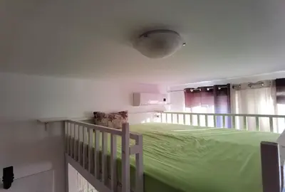 a bedroom with a green bed and a crib at Family Studio flat in Tŭnkovo
