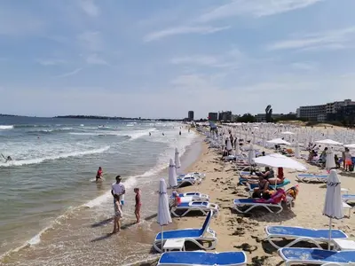 a beach with a lot of chairs and people on it at Family Studio flat in Tŭnkovo