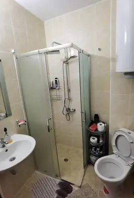 a bathroom with a shower and a toilet and a sink at Family Studio flat in Tŭnkovo