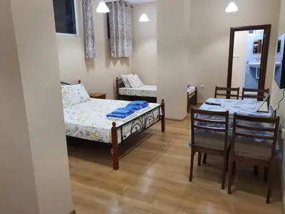 a small room with a bed and a table and chairs at Студио Морски бриз in Pomorie