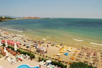 a beach filled with lots of people and the ocean at VIGO Nessebar in Nesebar